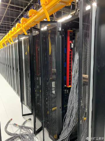A miner inspecting rows of Antminer S9 units in a mining farm.