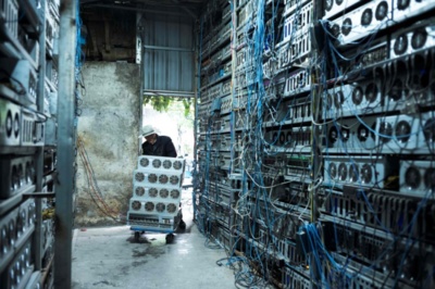 Rows of mining rigs in a large, well-ventilated mining farm, highlighting the scale of operation and efficient cooling systems.