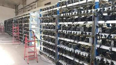 A modern mining farm with rows of mining rigs
